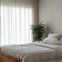 A serene and minimalist bedroom setup with dim lighting, representing an optimized sleep environment.